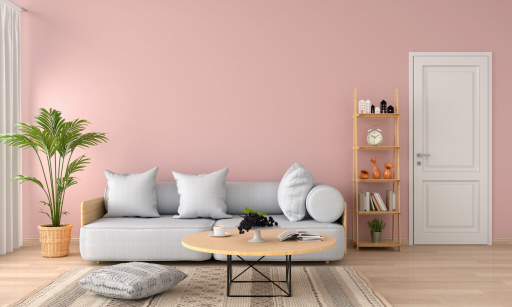 Graues Sofa und Kissen in rosafarbenen Wohnzimmer, moderner Einrichtungsstil.