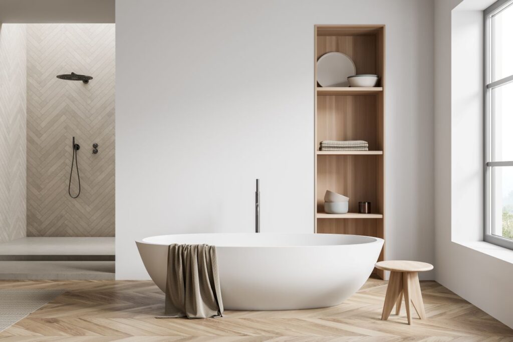 Stilvolles Badezimmer mit freistehender Badewanne, natürlichem Holzregal und fugenloser Wandverkleidung in der Dusche für ein minimalistisches Design.