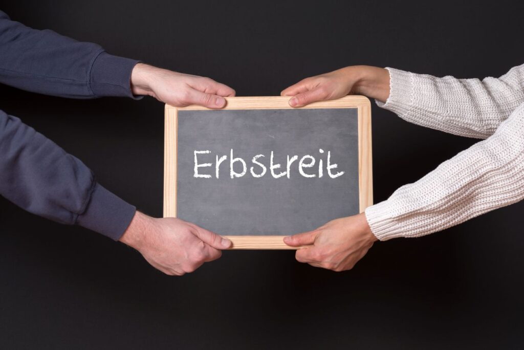 Zwei Personen ziehen an einer Tafel mit der Aufschrift „Erbstreit“ – Symbol für Konflikte um das Erbe. Erfahren Sie, wie Sie Erbstreitigkeiten in Würzburg vermeiden können.