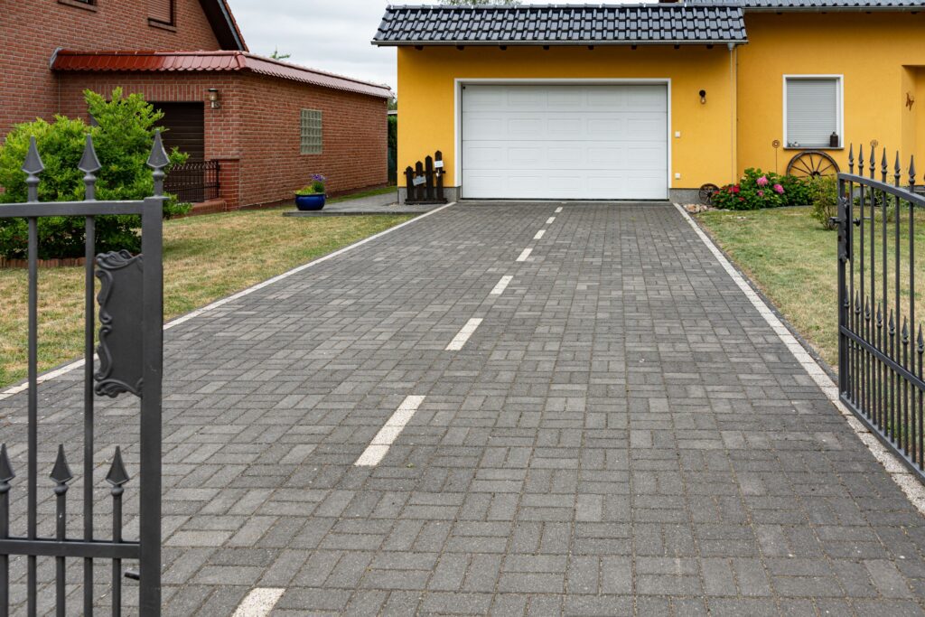 Private gepflasterte Einfahrt mit aufgebrachter Parkflächenmarkierung vor einem Einfamilienhaus