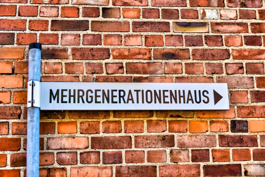 Schild Mehrgenerationenhaus an Backsteinwand | Plattformlift